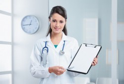 Confident woman doctor pointing at the clipboard